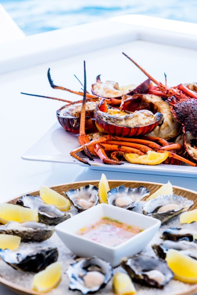 A delectable seafood platter featuring lobsters and oysters with lemon wedges, perfect for gourmet dining.
